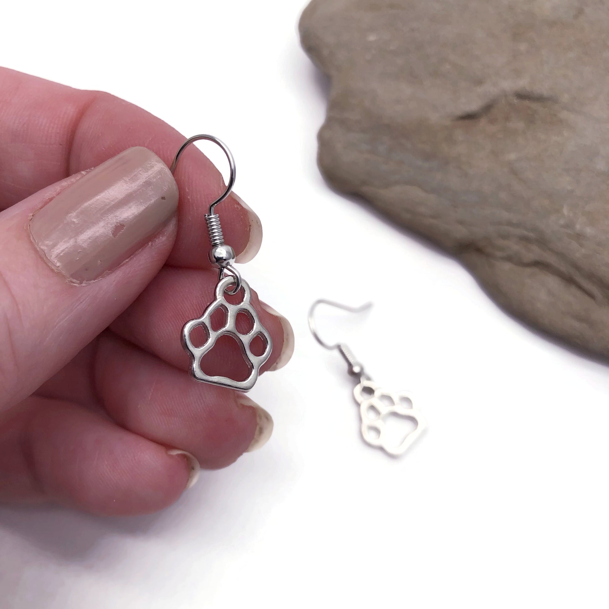 Paw print charm earrings in hand